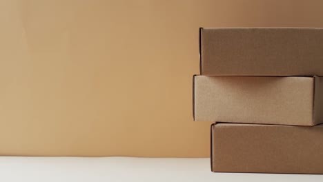 video of stacked cardboard boxes with copy space over brown background