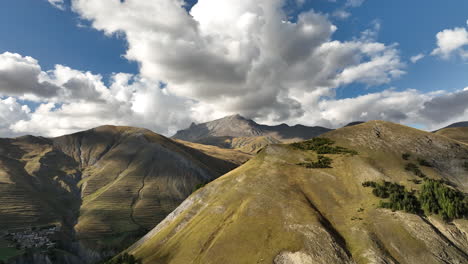 close aerial shot along rocky peaks discovering a valley with glacier