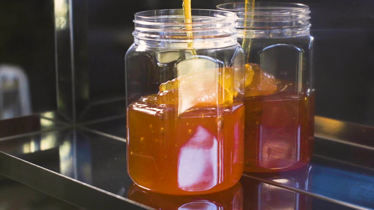 un frasco entero de miel llenándose