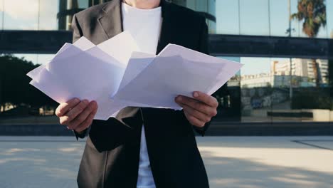 businessman checking documents outside, man boss ceo employee in formal outfit holding and reading cv, getting ready for job interview, standing outdoors on the street