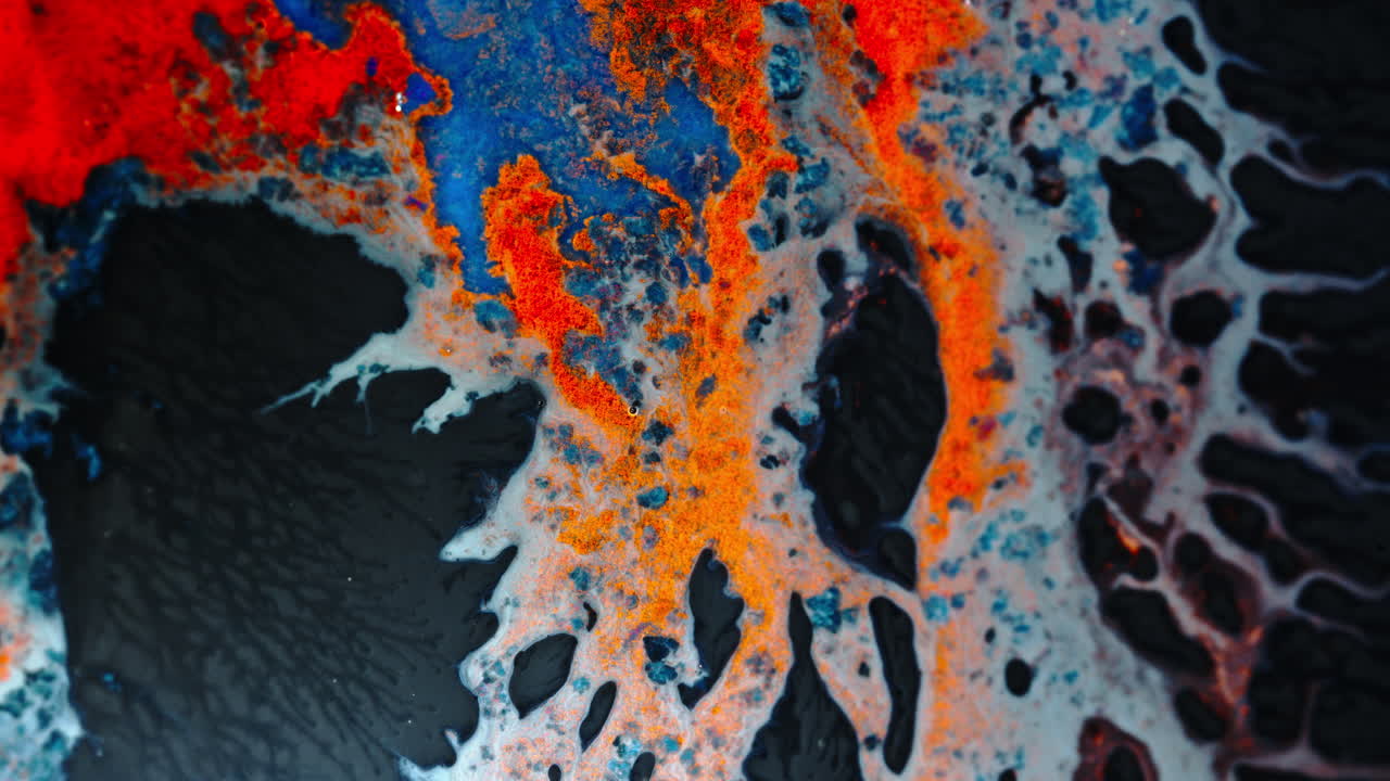 Colorful macro shot of ink blending in liquid, creating vibrant swirling patterns