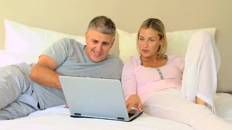 pareja mirando una computadora portátil