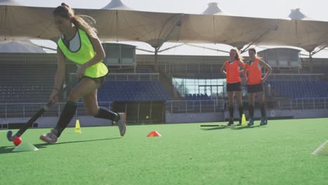 jugadoras de hockey entrenando en un campo