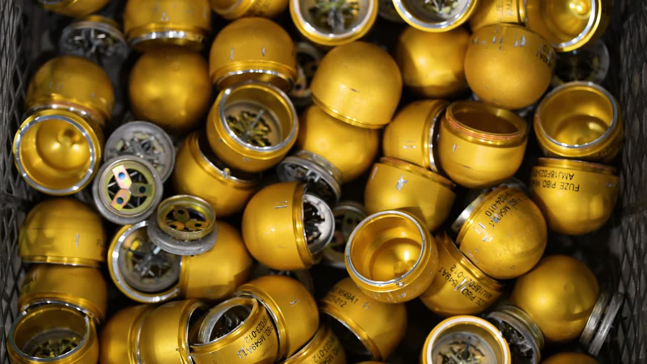 Grenade casings are prepared for modification with plastic for drone attachment at a workshop in Ukraine's Donetsk region. Showcasing adaptive weapon tech for modern warfare.