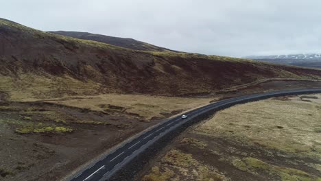 seguimiento aéreo detrás del coche conduciendo a través del valle de la montaña kaldidalur