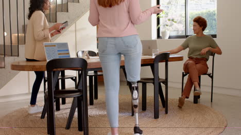 woman with prosthetic leg walking towards female friends, engaging in conversation