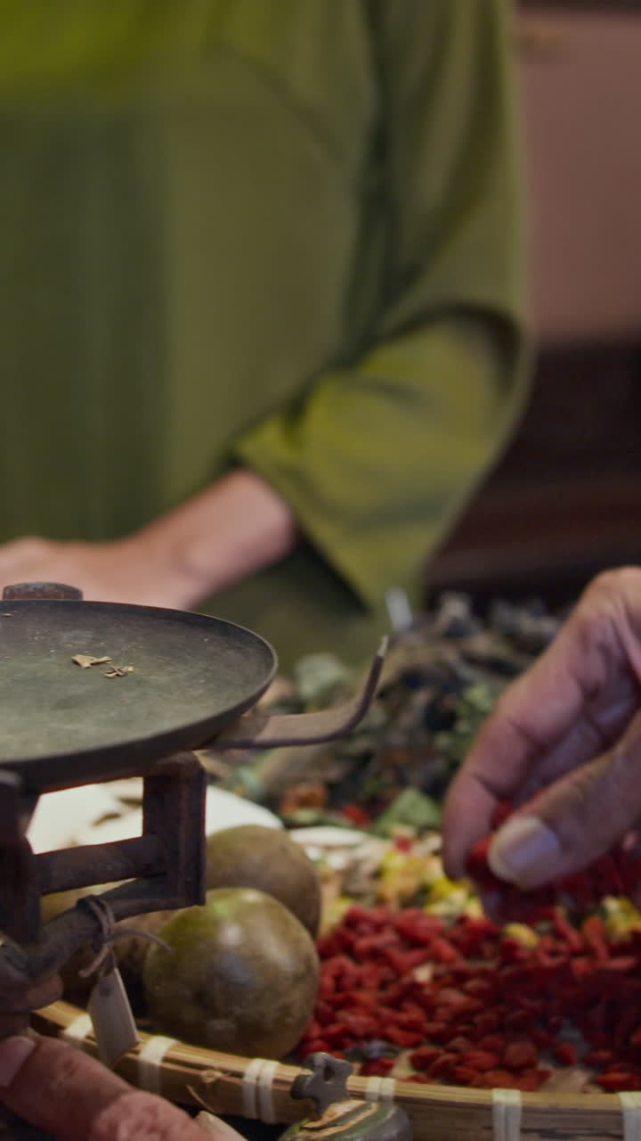 Hands of Herbalists Weighing Dried Ingredients on Scales