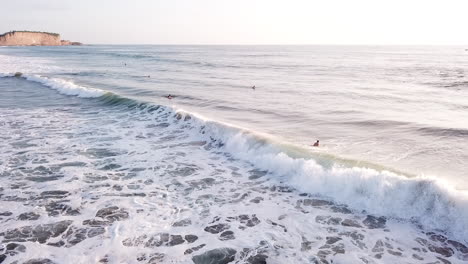 grandes olas del océano salpicando con surfistas disfrutando de vacaciones de verano en la playa de olon, ecuador