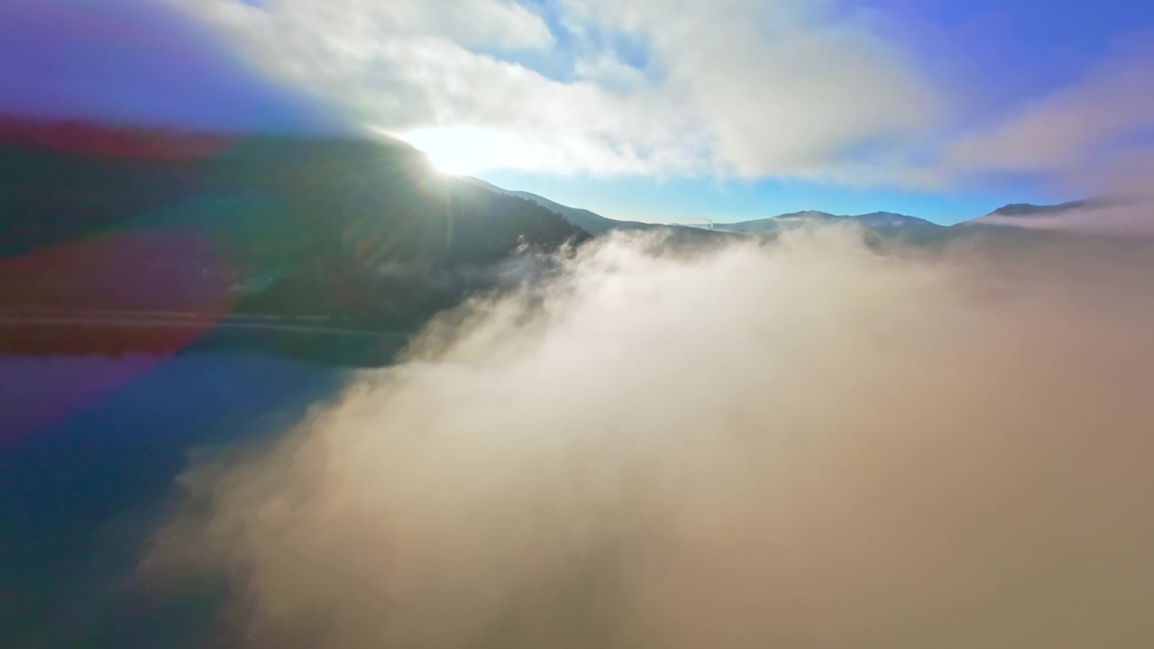 Vista aerea di un lago nebbioso e montagne boscose all'alba