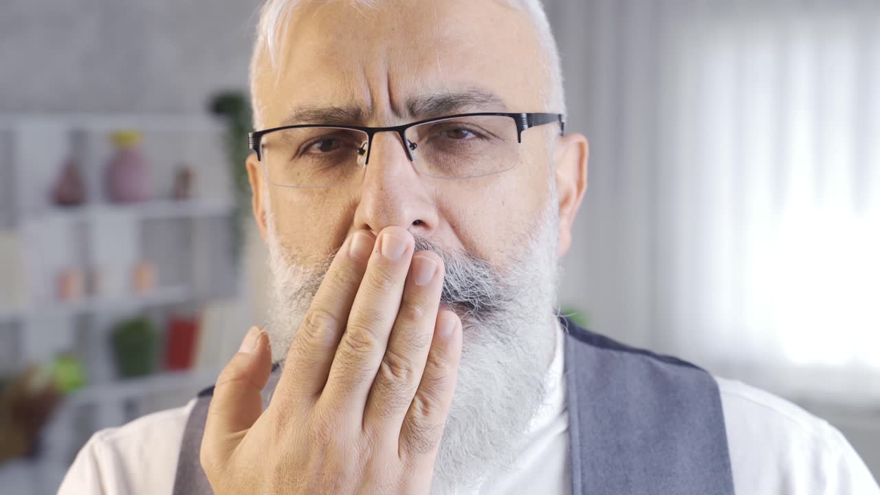 el hombre soñoliento bosteza y los ojos cansados.