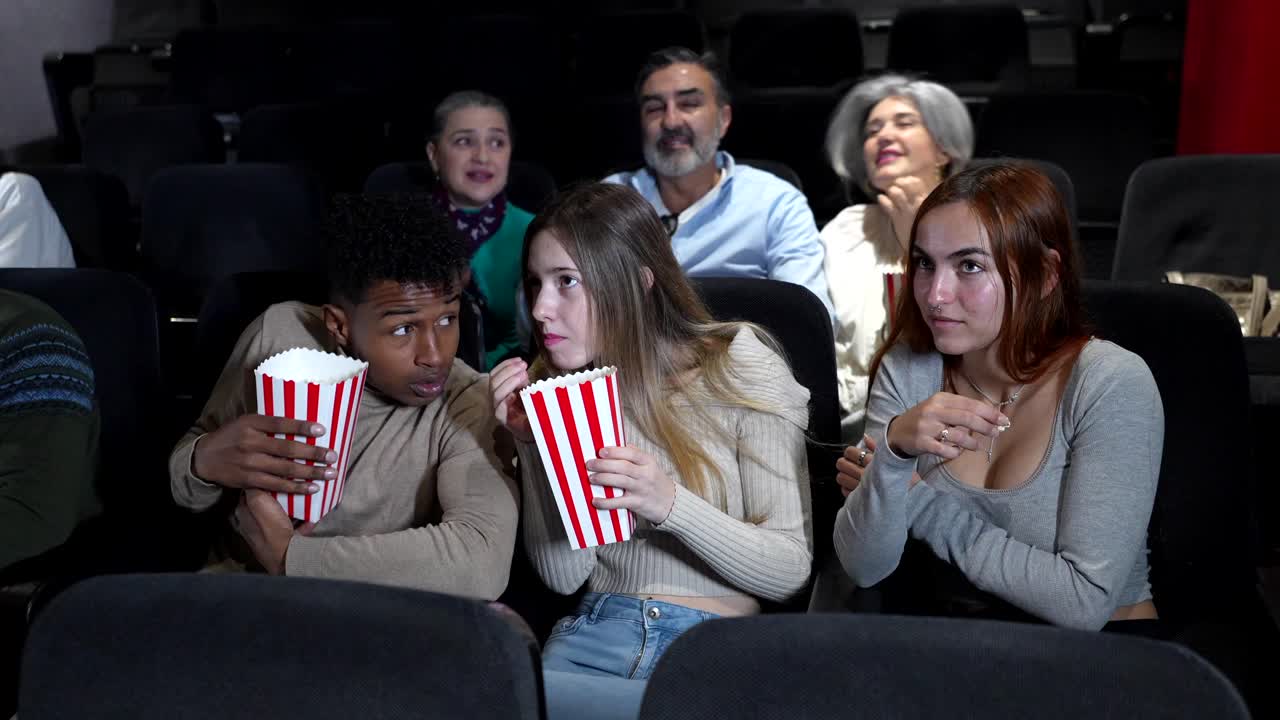 People watching a scary movie in a movie theater