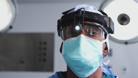 portrait of male surgeon with protective glasses and head light and  mask in hospital operating theater
