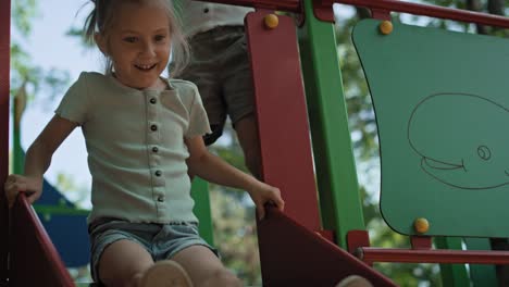 Caucasian-girl-playing-at-sliding-in-summer-day.