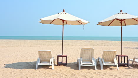 empty beach chairs parasols and tropical sea during covid-19 travel restrictions economy loss concept, static full frame