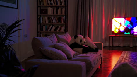 panda on a sofa in a living room at night