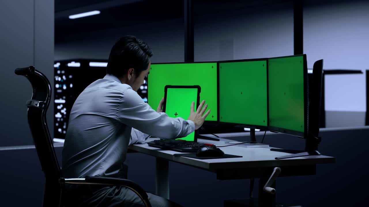 그것은 녹색 화면 모니터와 태블릿과 함께 서버 에서 밤에 일하는 전문