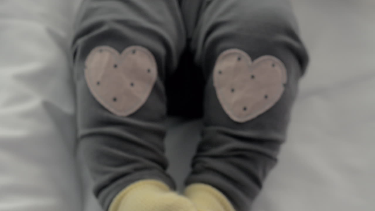 niña activa con calcetines y pantalones amarillos con corazones