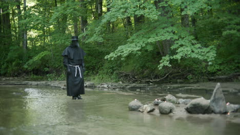 médico de la peste caminando por un arroyo