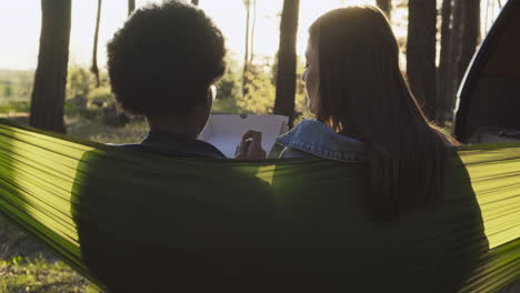 dos bestias sentadas en sus hamacas en el bosque