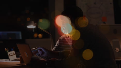 Businessworkers woking over laptop on night at office with colorful bubble animation