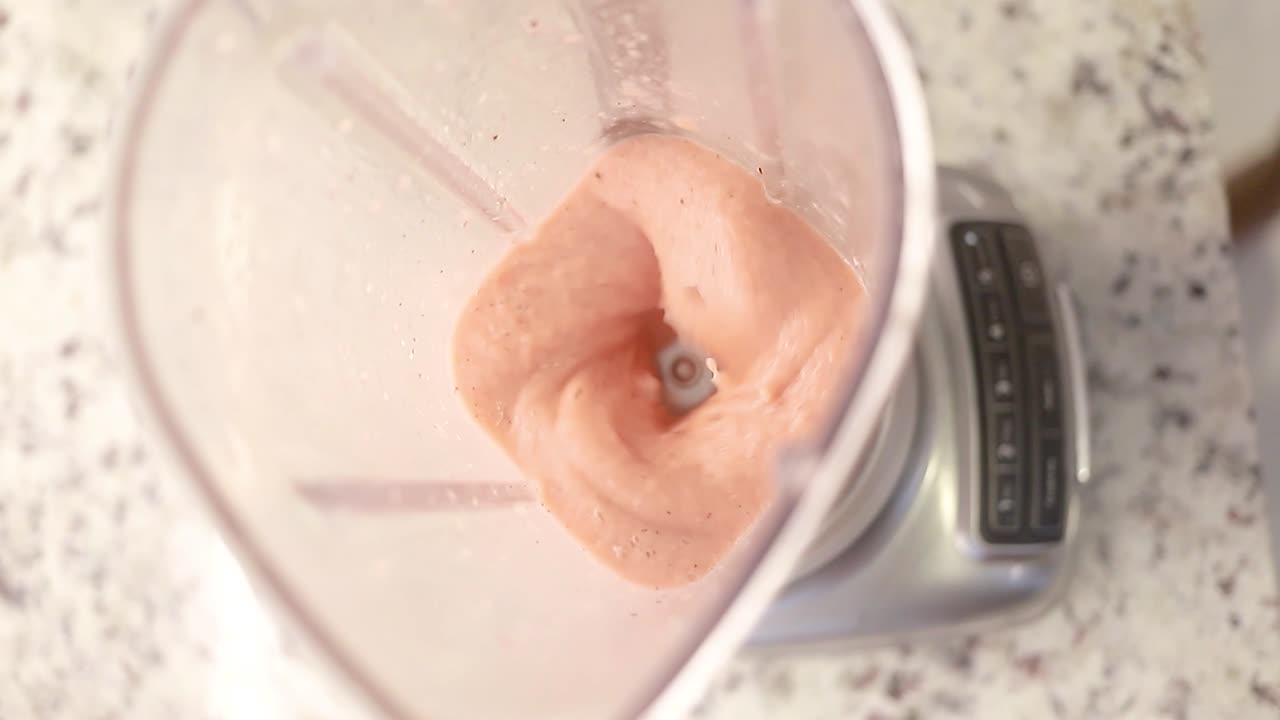 vista superior de una licuadora preparando un batido natural, cámara lenta