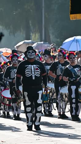day of the dead parade with marching band in skeleton costumes