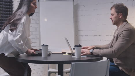 Man-And-Woman-Having-A-Business-Meeting-In-Boardroom