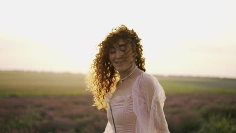 joyful redhead girl in pink dress whirls on lavender field