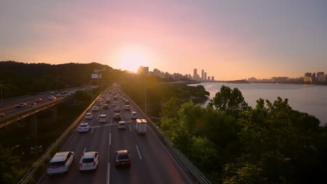 Puesta-De-Sol-De-Color-Rosa-Sobre-Un-Atasco-De-Tráfico-Ocupado-En-La-Autopista-Olímpica,-En-Tiempo-Real-Desde-El-Puente-Dongjak,-Seúl,-Corea-Del-Sur