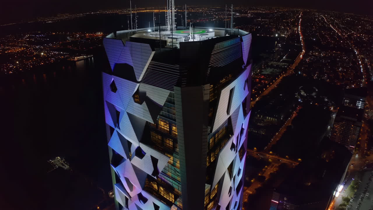 Modern Skyscraper Illuminated at Night with City Skyline