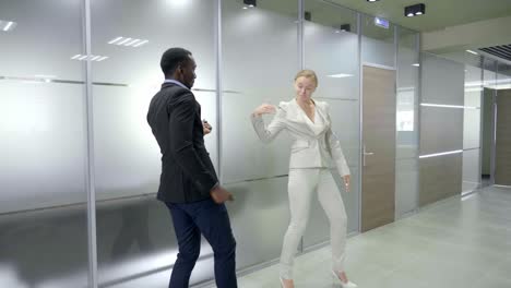 business people dancing in modern office corridor
