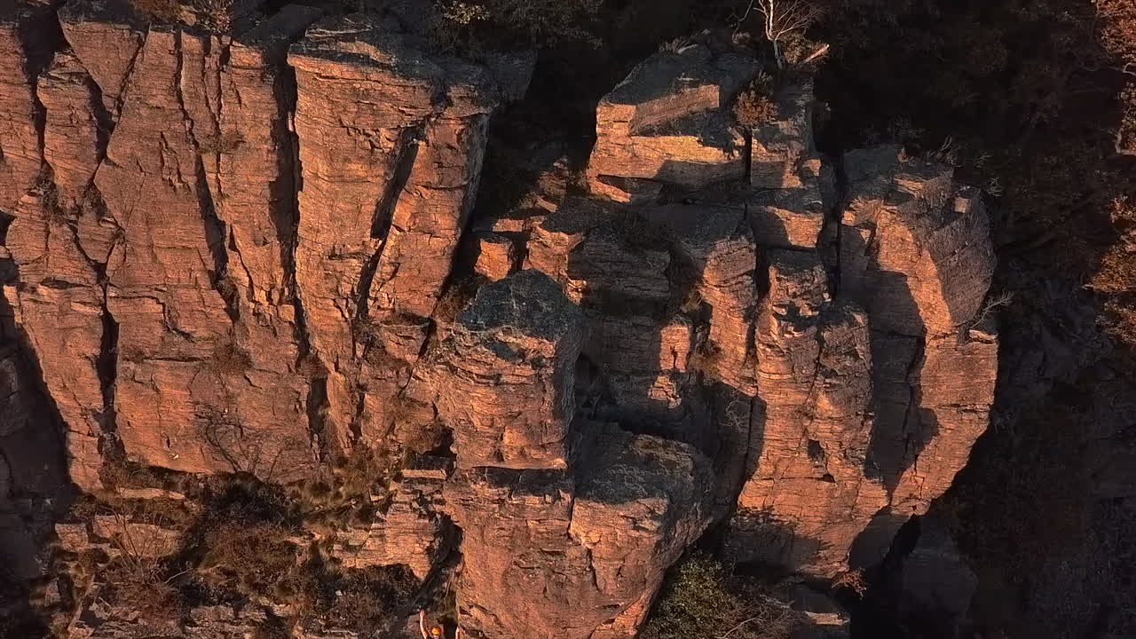 Aerial View of Rock Climber on Steep Cliff Face