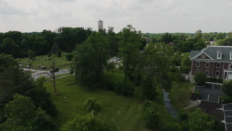 aerial rising in indiana state park in lawrence, water tower on distance