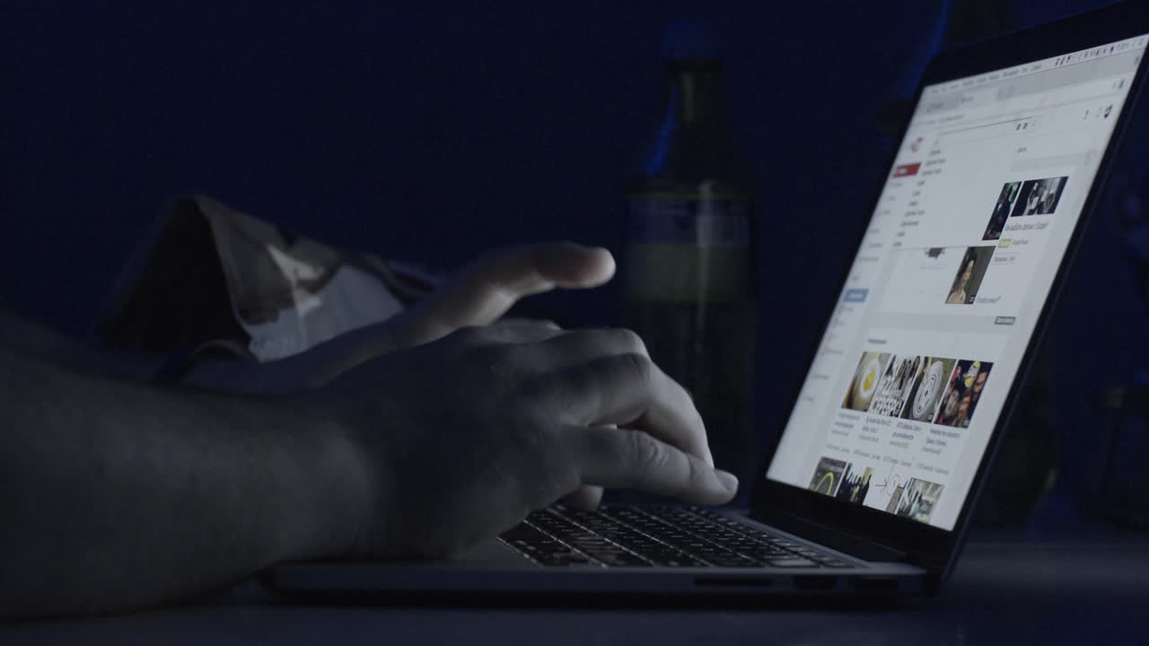 persona que trabaja en una computadora portátil por la noche