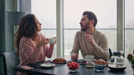 una pareja feliz bebiendo café en la cocina de city view.