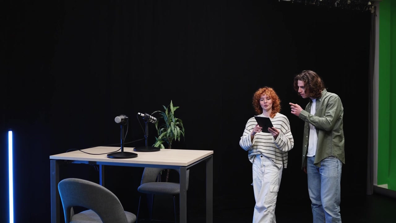 Mladí lidé probírající vybavení pro podcast ve studiu