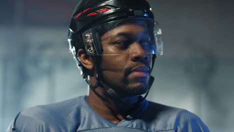 close-up van een gelukkige mannelijke hockeyspeler die vrolijk naar de camera kijkt en koude lucht inademt op de ijsarena 1