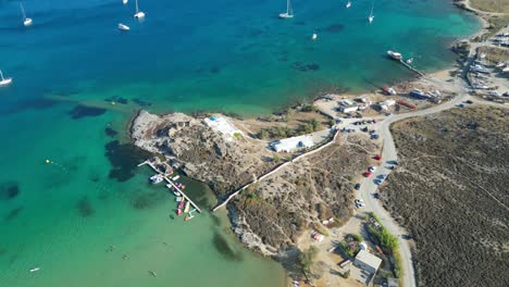 Imágenes-Aéreas-De-Aguas-Turquesas-Y-Un-Pequeño-Club-De-Playa-En-La-Isla-De-Paros,-Una-De-Las-Muchas-Islas-Cícladas-En-El-Mar-Egeo.