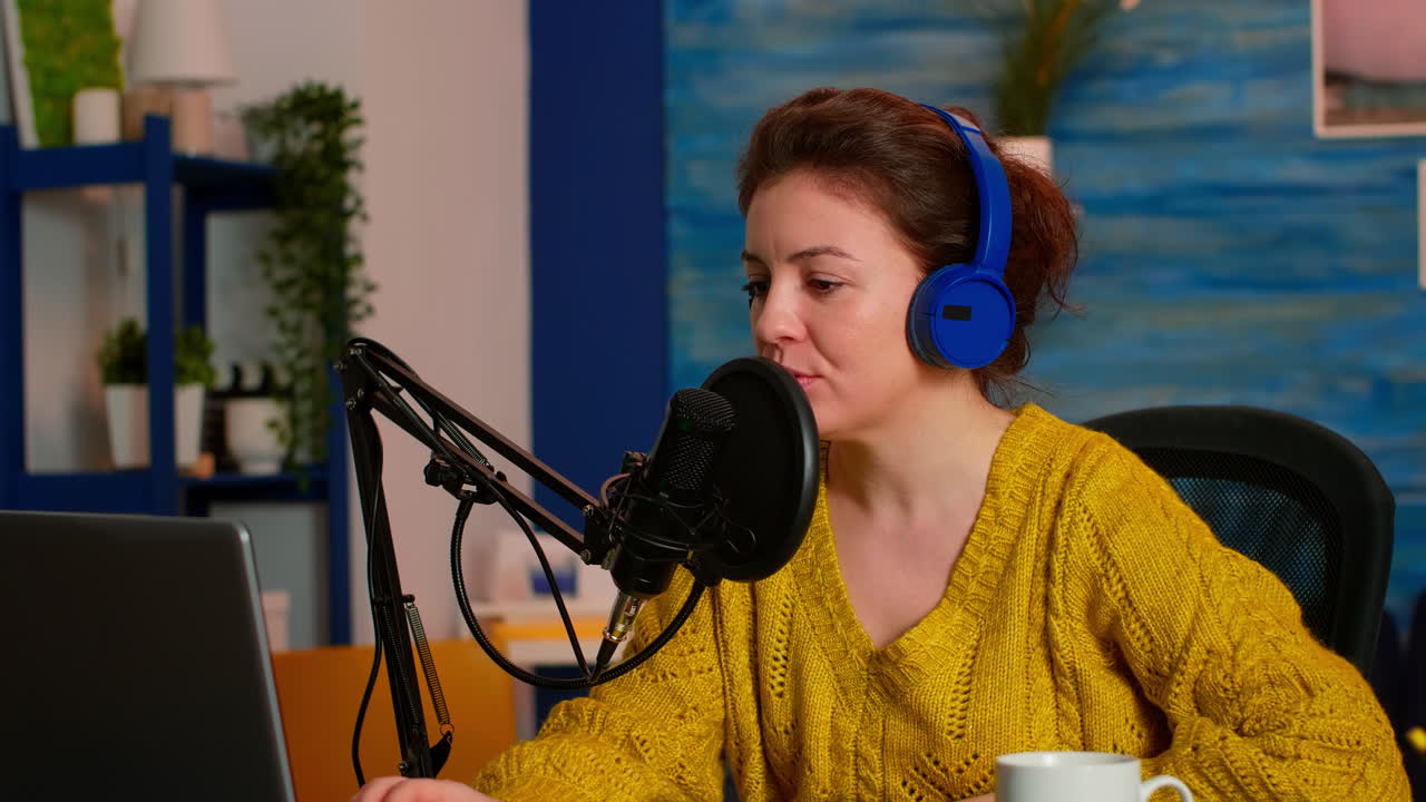 Kvinde der optager en audiopodcast på en bærbar computer