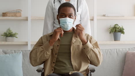 man in wheelchair with doctor wearing a mask
