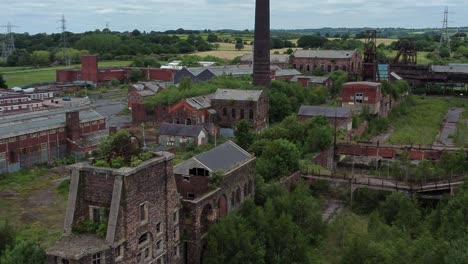 Verlassene-Alte-überwucherte-Landschaft-Kohlenmine-Industriemuseum-Gebäude-Luftaufnahme-Zoomen-Hinein