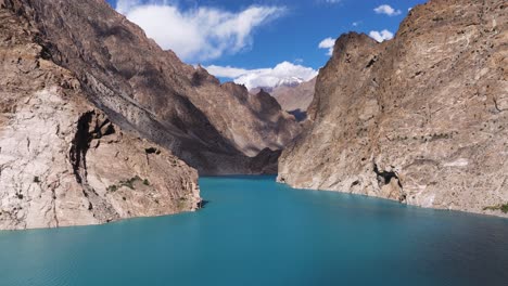 stunning aerial view above attabad lake in hunza valley, pakistan, bright blue waters surrounded by towering mountains. summer day in nature.
