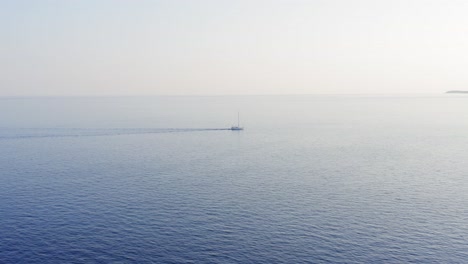 Big-sailboat-moving-slowly-on-a-calm-blue-sea,-bright-clear-sky