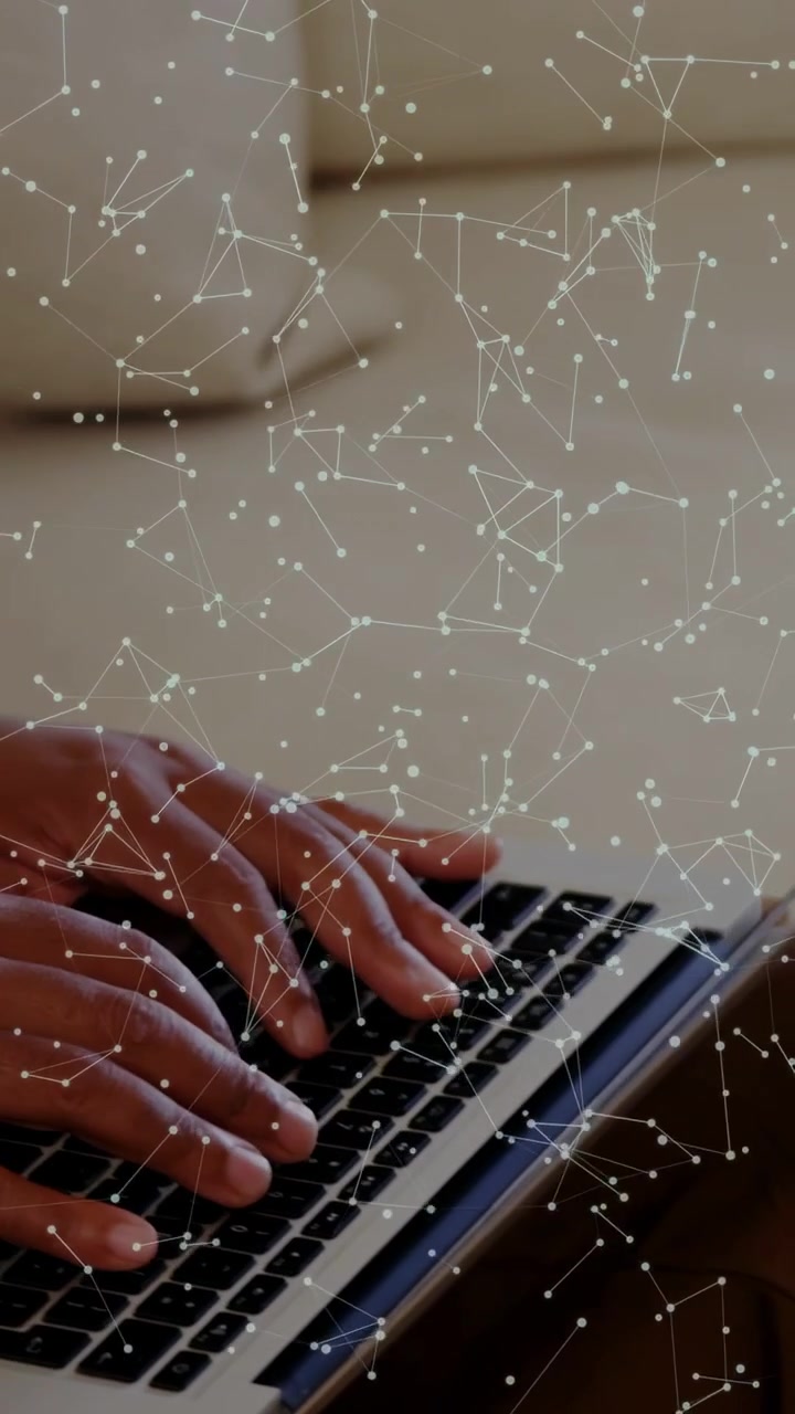 Vertical video: Man placing hands on laptop, typing with constellation overlay for tech demo