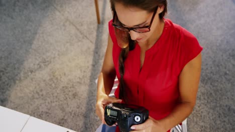diseñadora gráfica femenina usando una tableta gráfica y mirando una cámara digital
