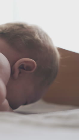 restless infant lies on stomach skilled nurse performs back massage and mother distracts attention close view