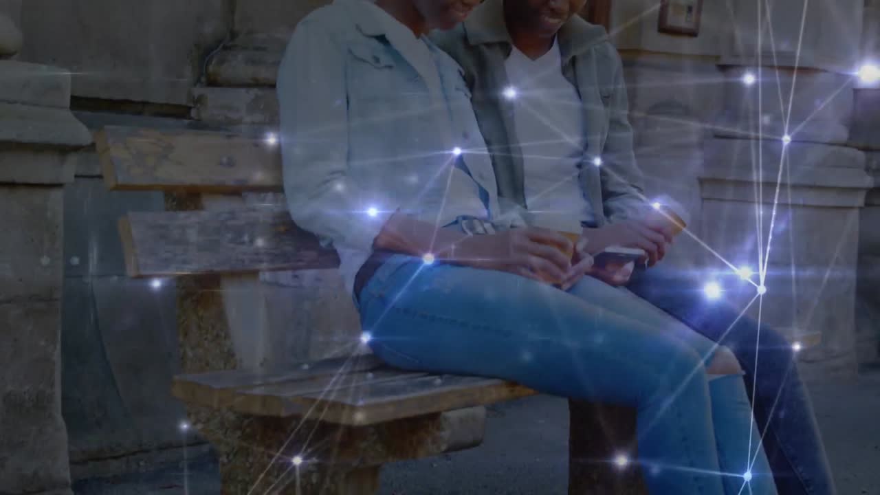 Animation of connections over happy african american twins women using smartphones