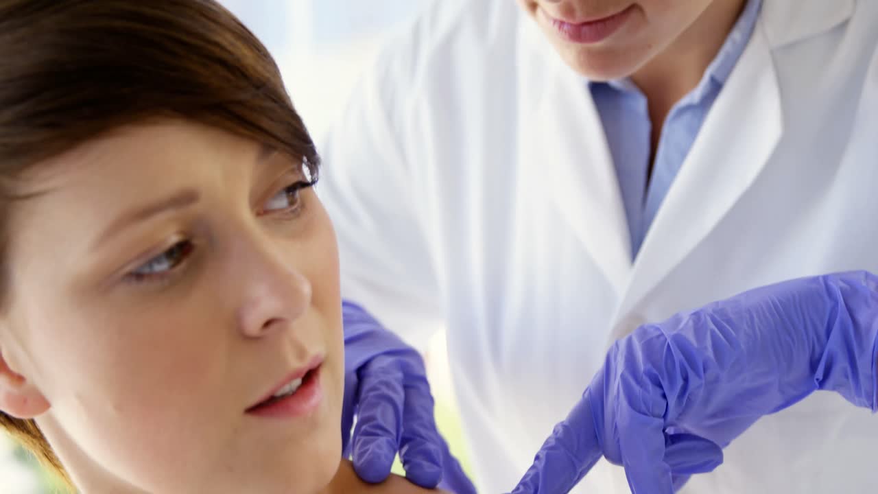 여성 치료사가 환자의 모를 가리키고 있습니다.