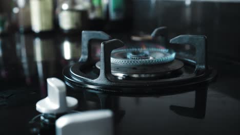 video of a black gas stove with blue and red burning flame in the kitchen