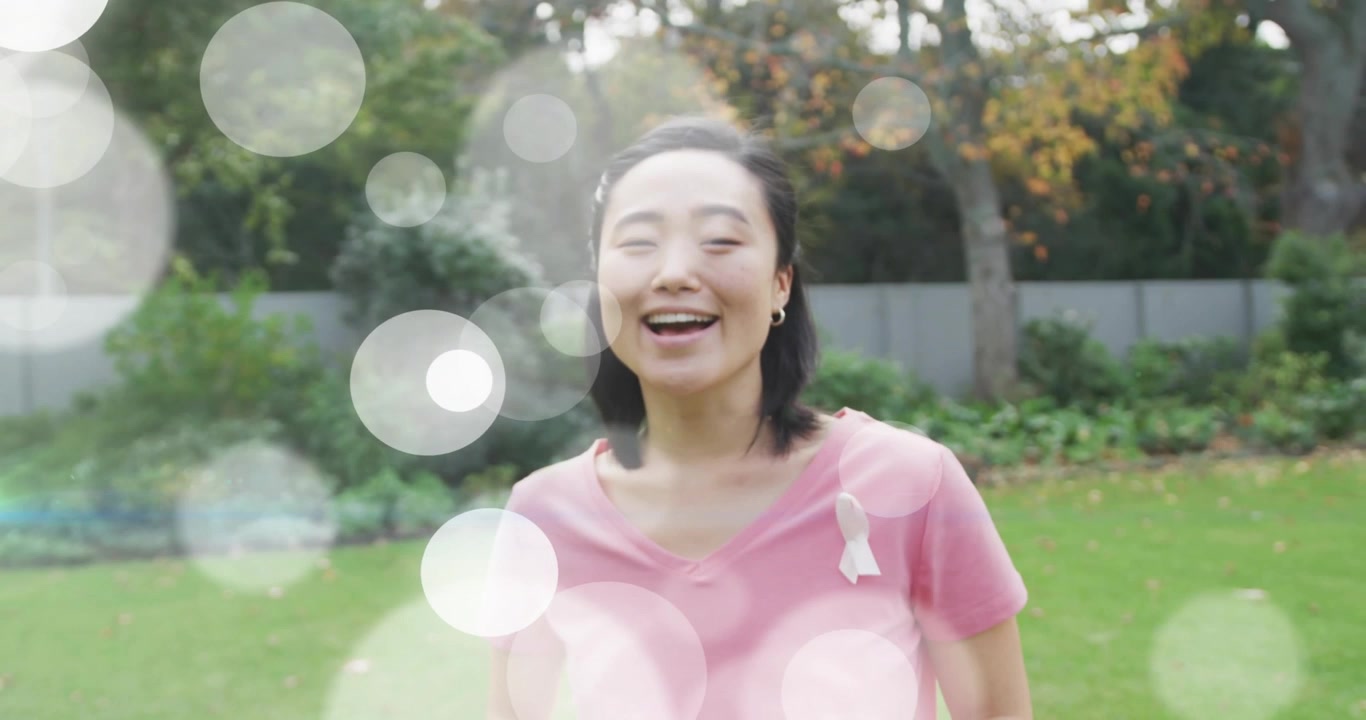 ボケライトが漂い、きらめく中、女性が穏やかに呼吸し、目を開けて微笑む。健康啓発のための映像。